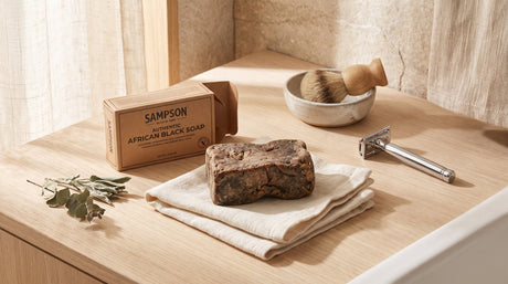 African Black Soap bar beside a razor and linen washcloth for a shave routine