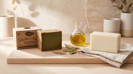 Traditional Aleppo Soap bar next to a plain Castile-style soap bar with bay laurel leaves and olive oil, comparing the two soap traditions
