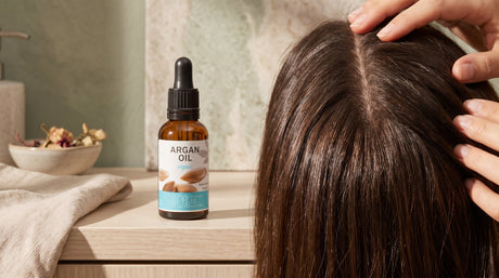 Argan oil pipette bottle beside hair being parted to show the scalp - Sampson Eco Shop