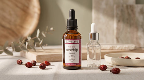 Sampson Rosehip Face Oil next to an unbranded serum dropper bottle, dried rosehips on linen